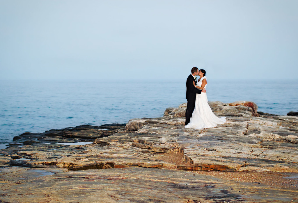 Couple kissing on rocks of Madison beach Hotel