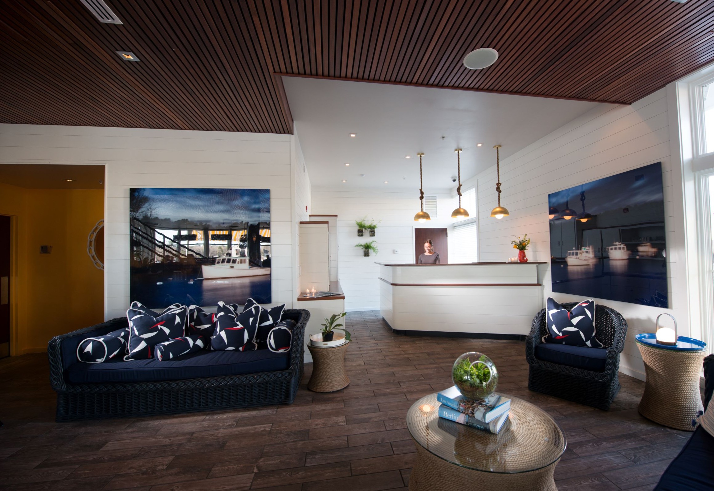 Modern lobby with blue sofas, artwork, and a white reception desk.
