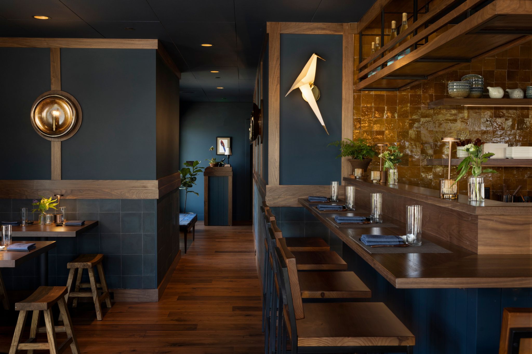Cozy restaurant bar with dark blue walls and wooden accents.