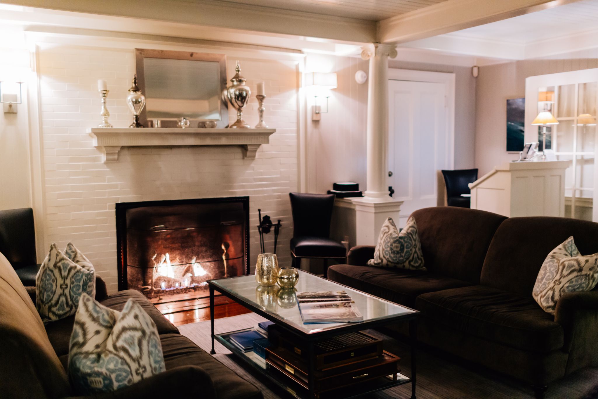 Cozy living room with a lit fireplace and dark sofas.