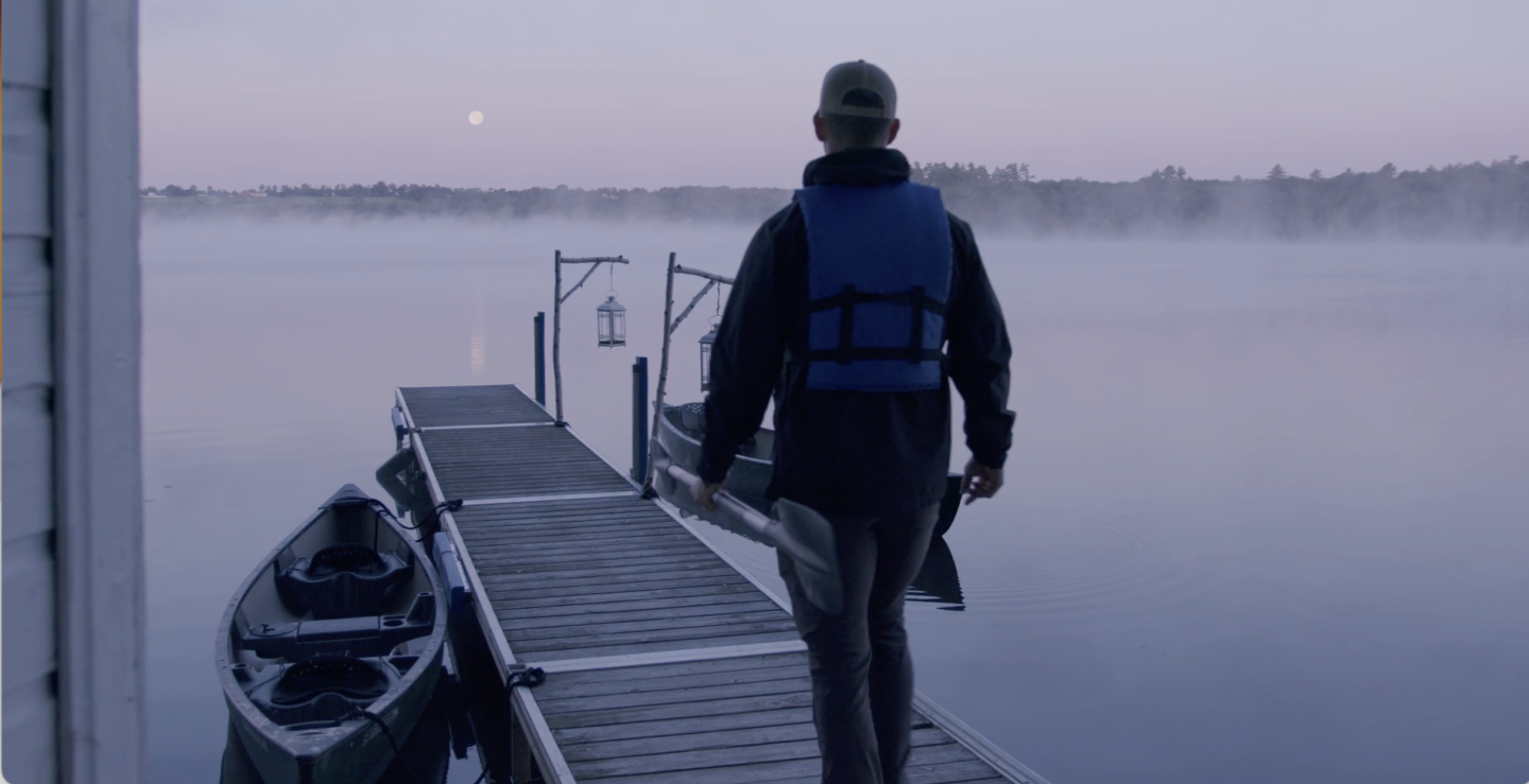 A guest walks to a canoe on Tripp Lake