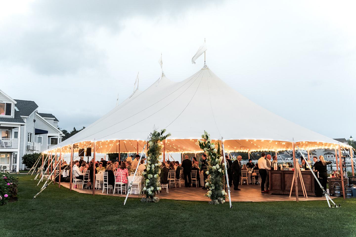 Close-up view of a sailcloth tent on the river’s edge, with soft lighting illuminating the fabric and highlighting the tent's elegant structure