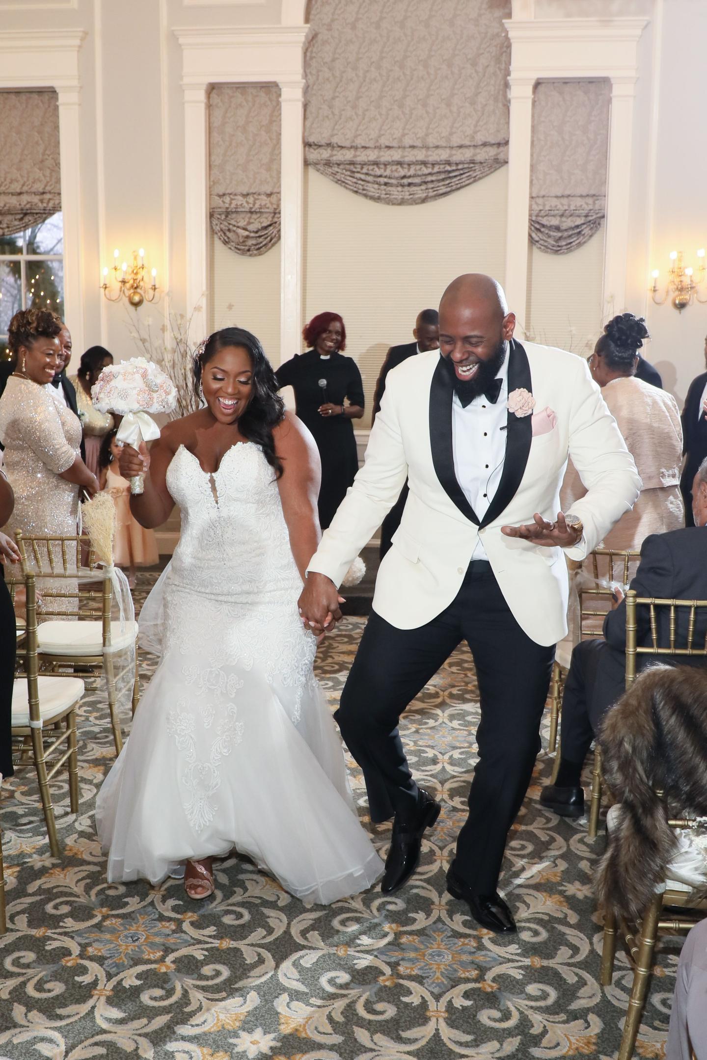 Bride and groom dancing joyfully in an elegant room.