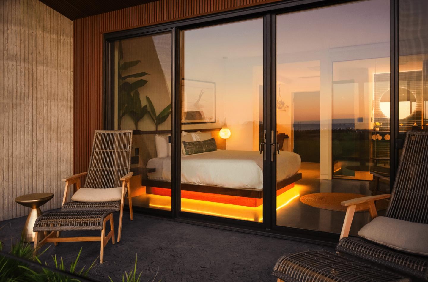 Sunset view of a cozy patio and modern bedroom with glowing lights.