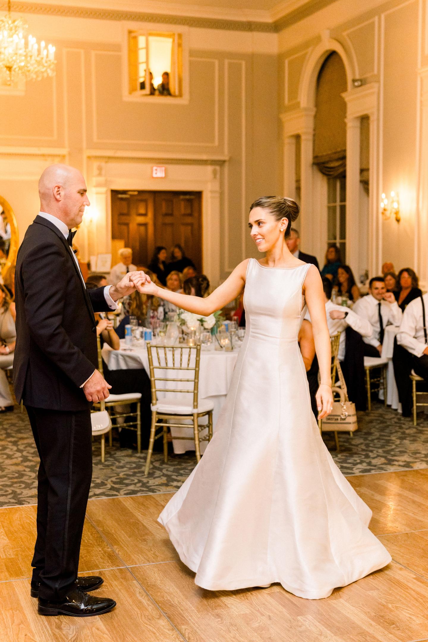 Bride and groom dancing at an elegant indoor wedding reception.