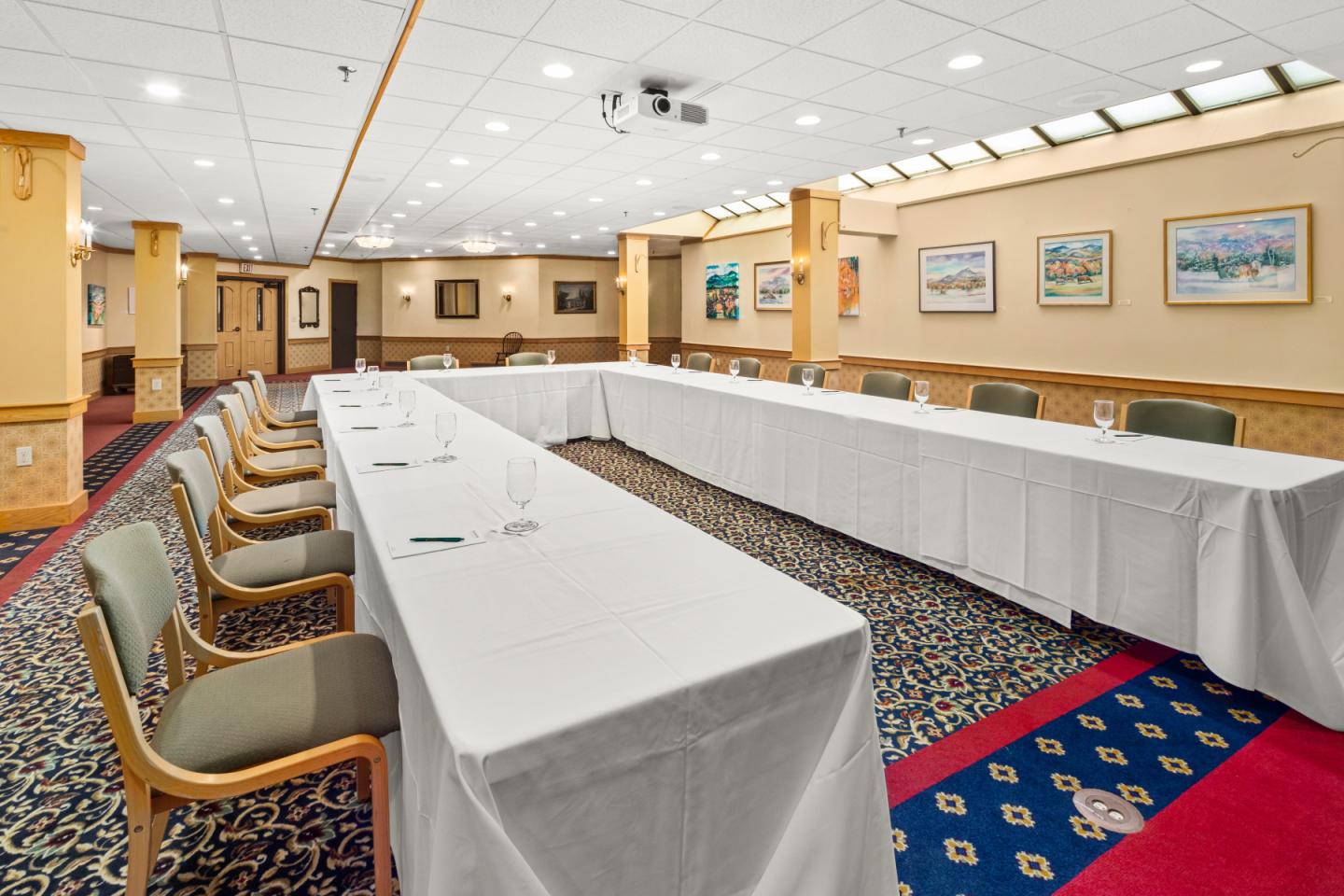 Conference room with U-shaped table arrangement and chairs.