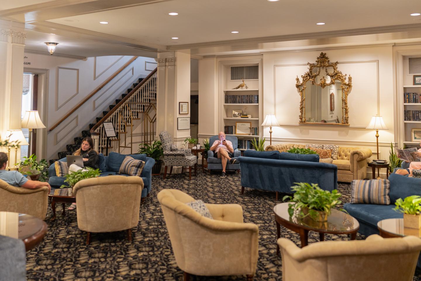 Elegant hotel lobby with plush seating and a staircase.