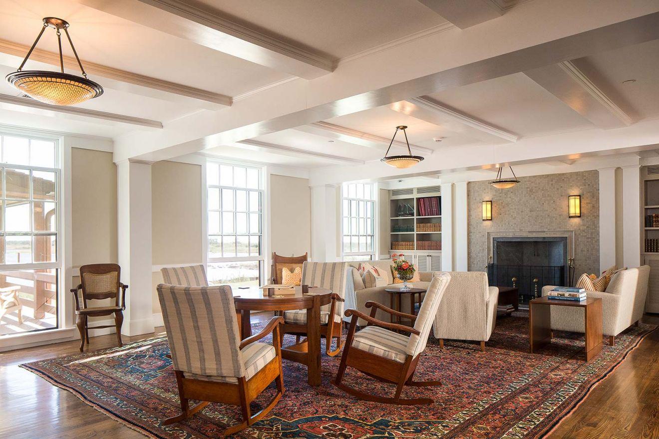 Cozy living room with armchairs, a sofa, and a fireplace on a patterned rug.