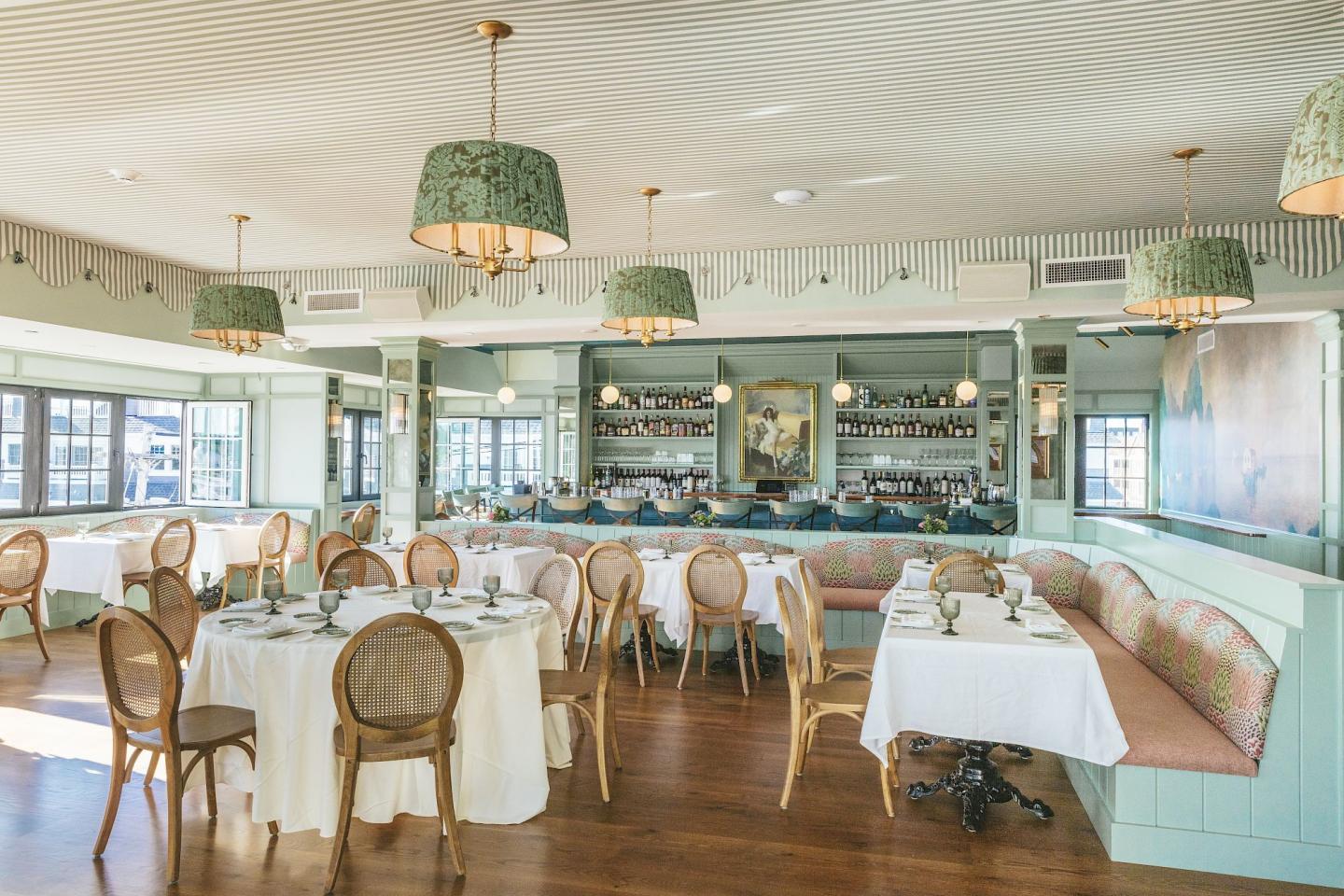 Elegant restaurant interior with pastel decor and round tables set for dining.