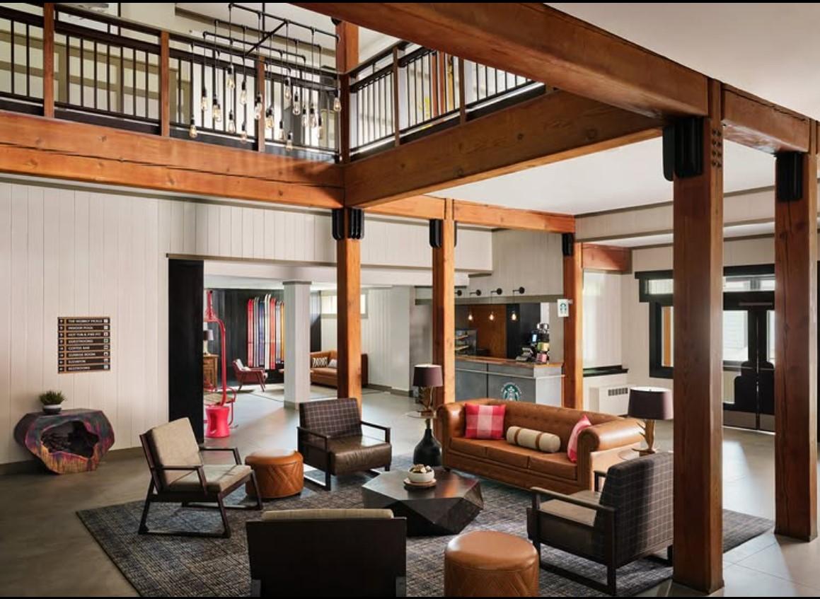 Spacious living room with modern furniture and wooden beams.Lobby
