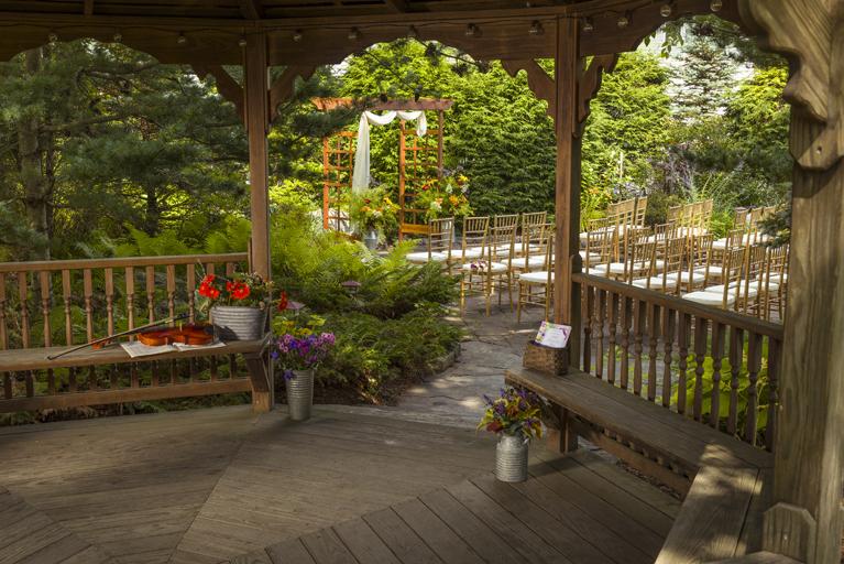 Gazebo with flowers and benches in a garden setting.