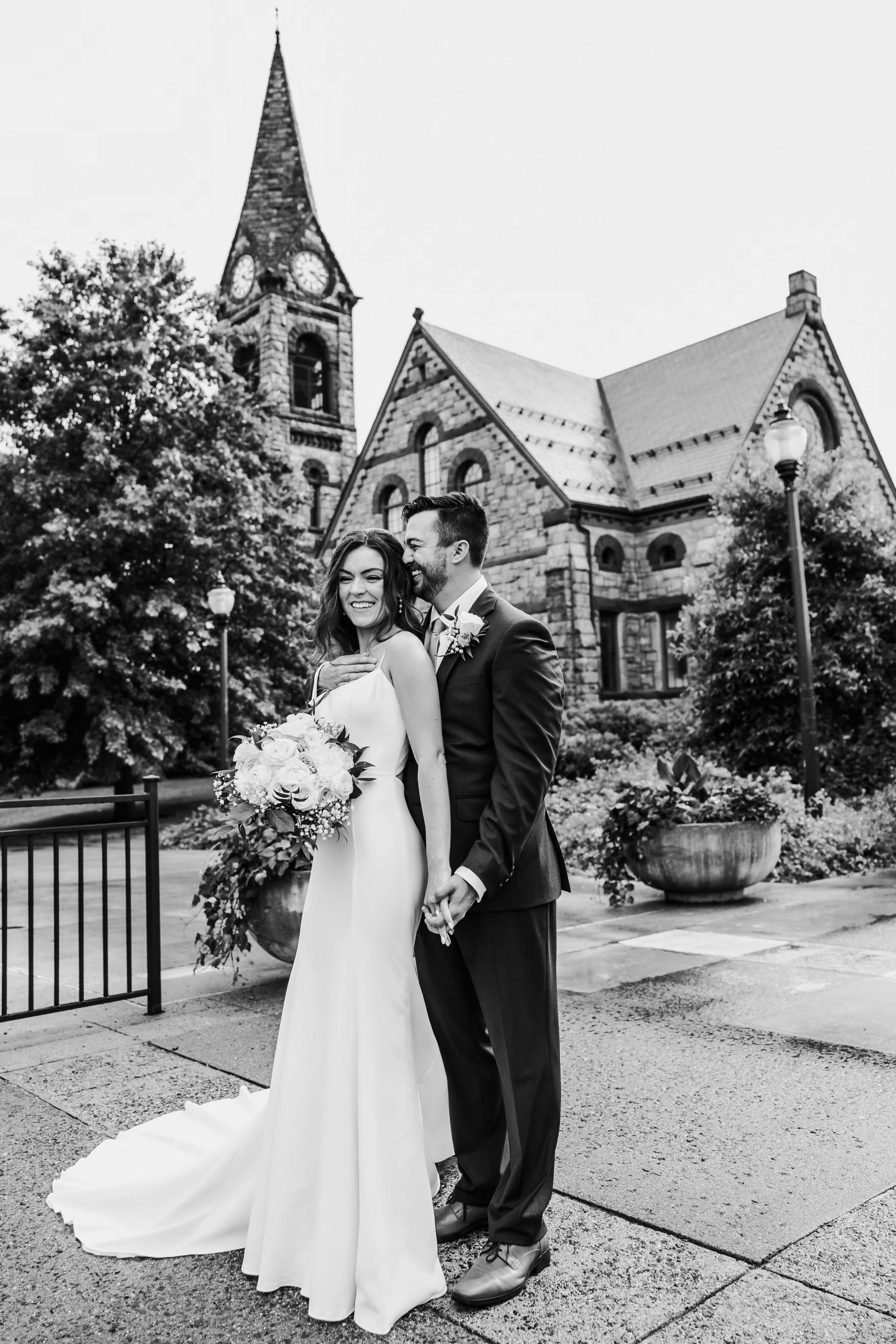 Bride and groom smiling, standing outside Old Chapel