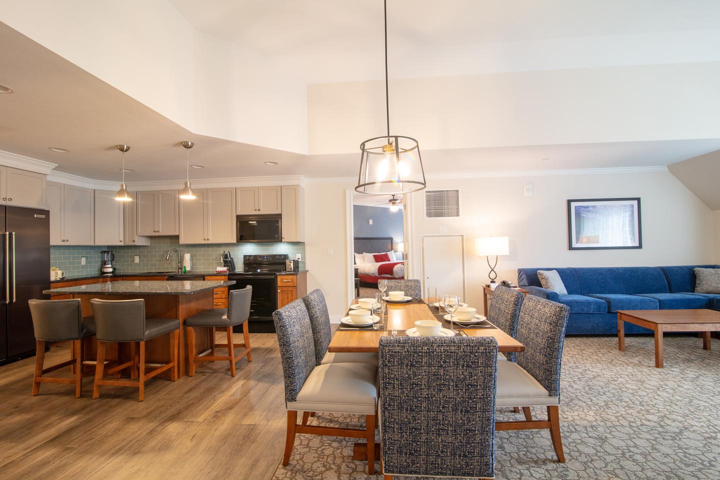 Dining and living area with a table, chairs, and a blue sofa.