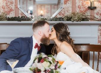 A couple kissing at their wedding reception.