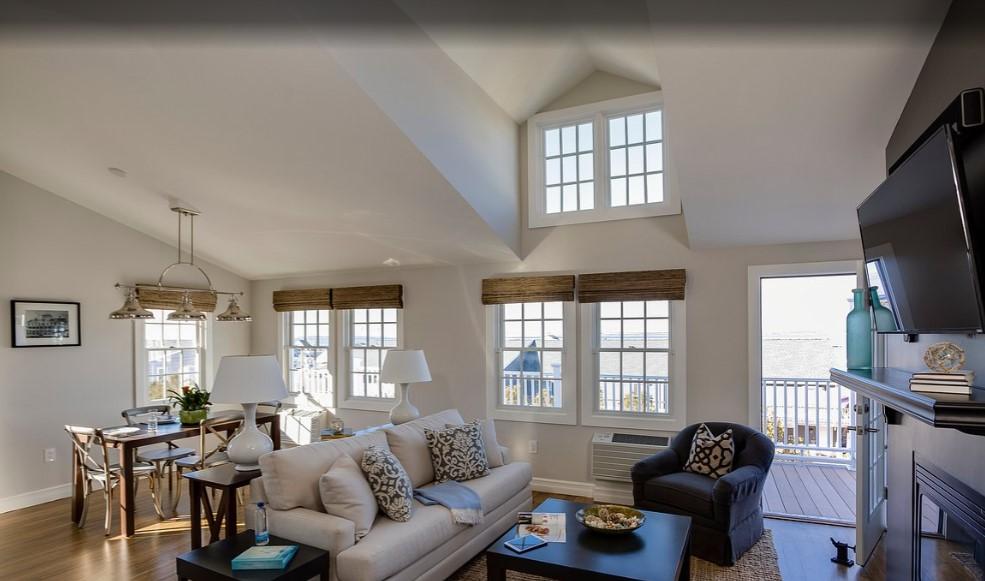 Bright living room with large windows, beige sofas, and a dining area.