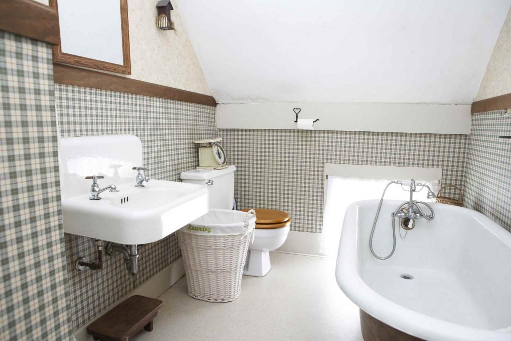 Classic bathroom with a freestanding bathtub, sink, and wicker basket.