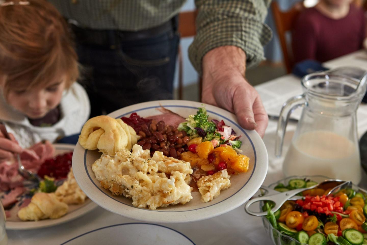 Thanksgiving meal being served, with a child's curious gaze.