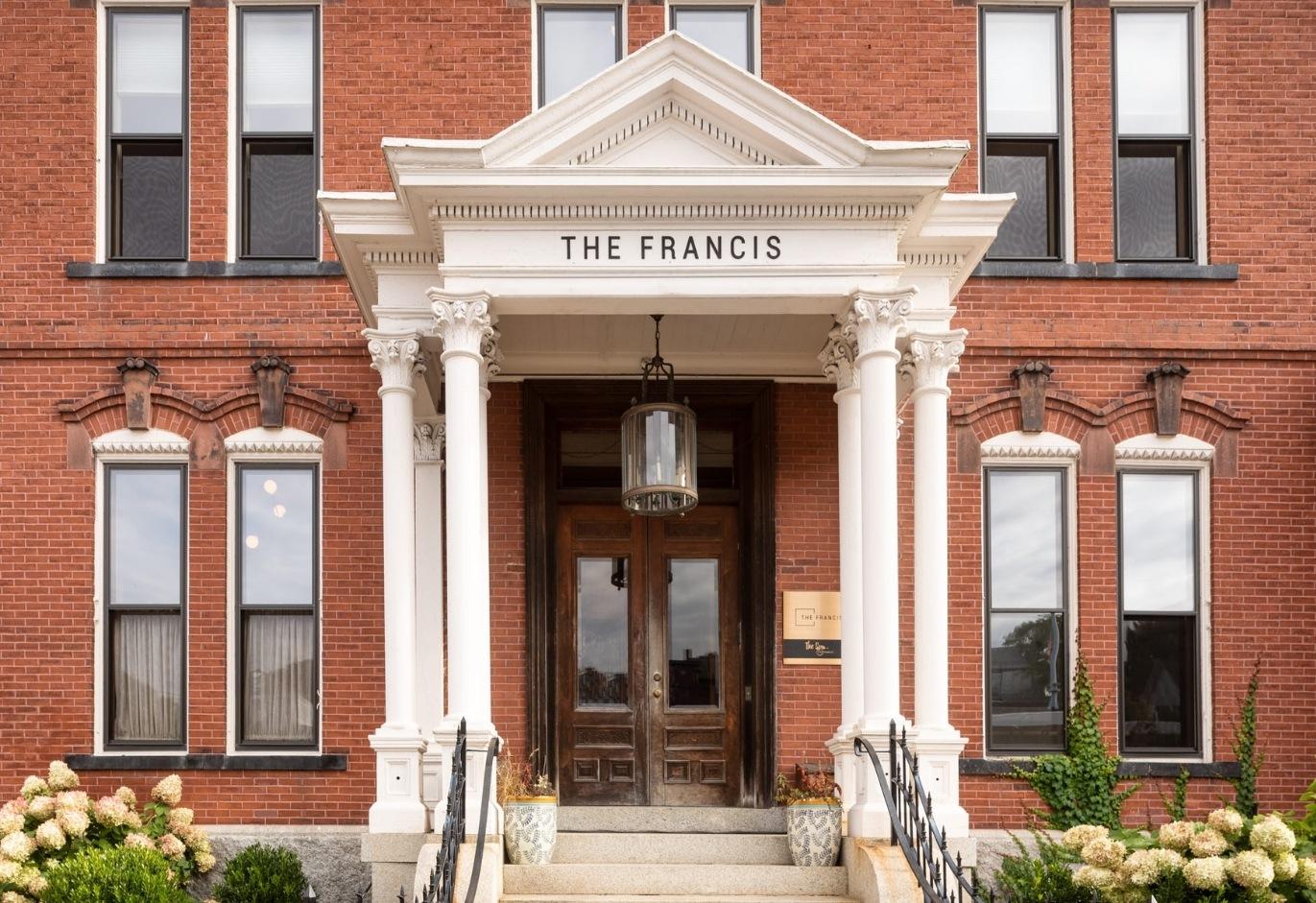 Historic red brick building facade with white columns and entrance.