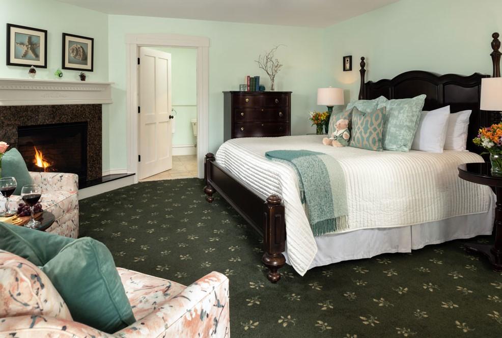 Cozy bedroom with a fireplace, large bed, and comfy chairs.