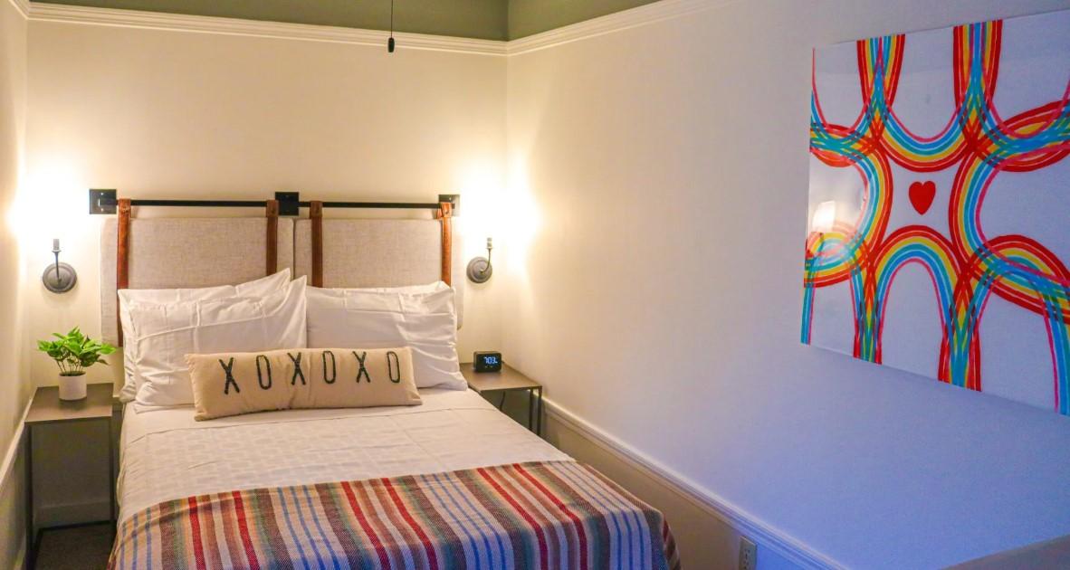 Cozy bedroom with a striped bedspread and colorful abstract artwork on the wall.