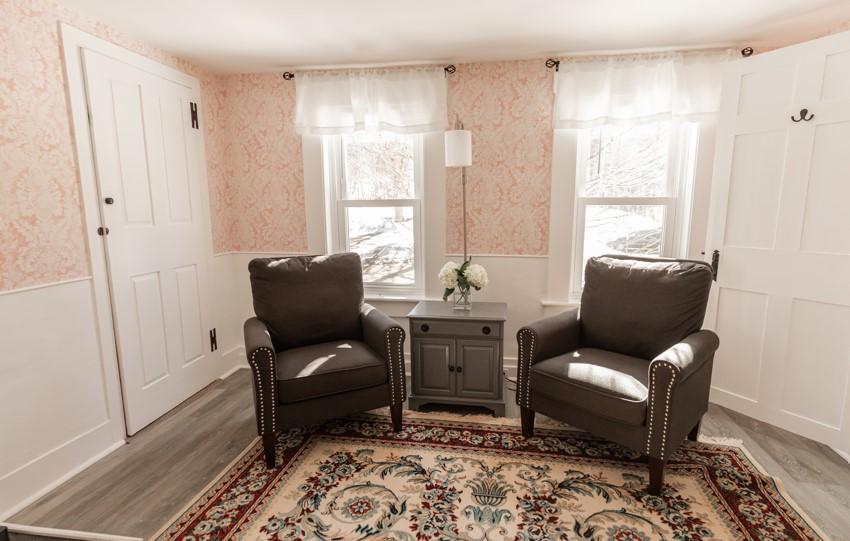 Two brown armchairs in a cozy room with a patterned rug and soft lighting.
