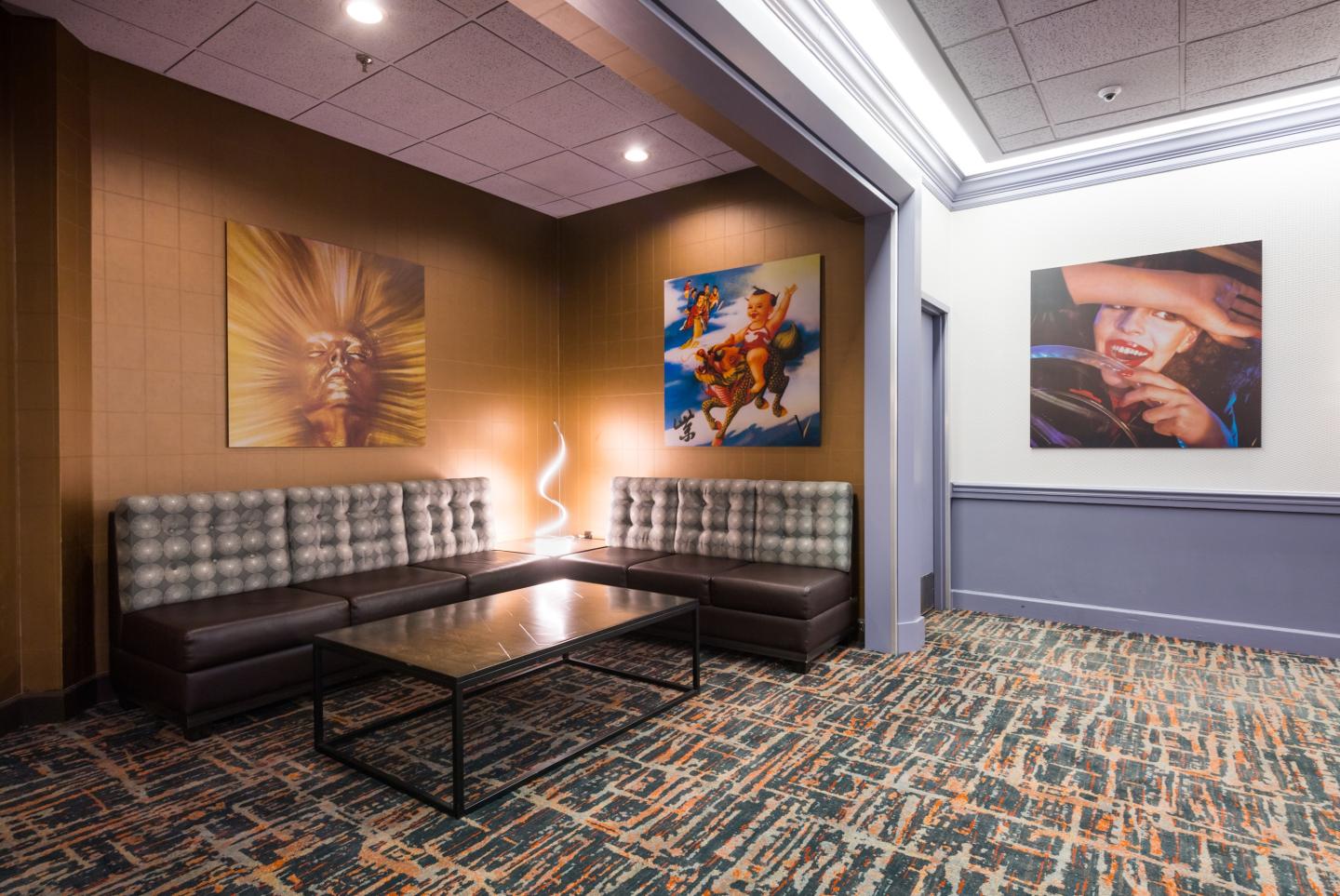 Modern lobby with plaid sofas, abstract wall art, and patterned carpet.