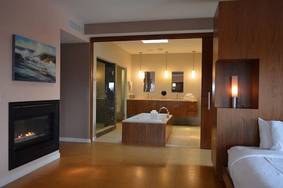 Luxurious hotel room with fireplace and open bathroom.