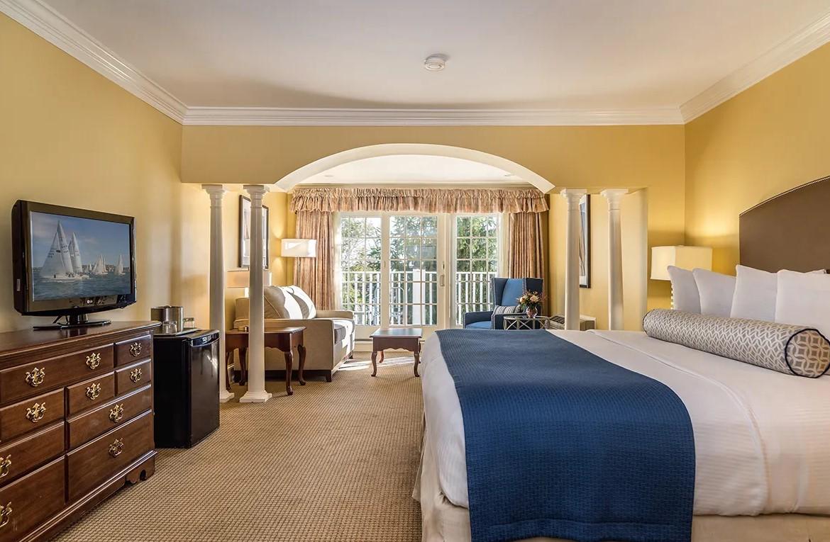 Luxurious hotel room with king bed, TV, and balcony view.