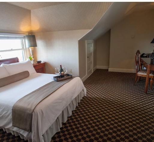 Cozy hotel room with a neatly made bed, desk, and window.