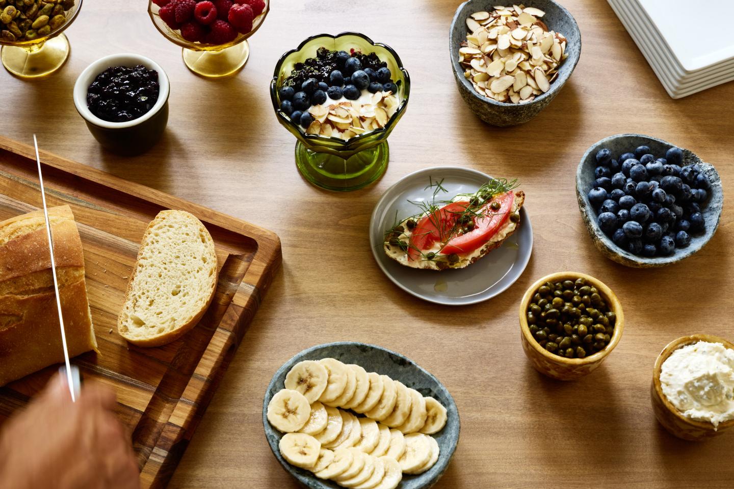 Sliced bread and assorted fruits on a wooden table.