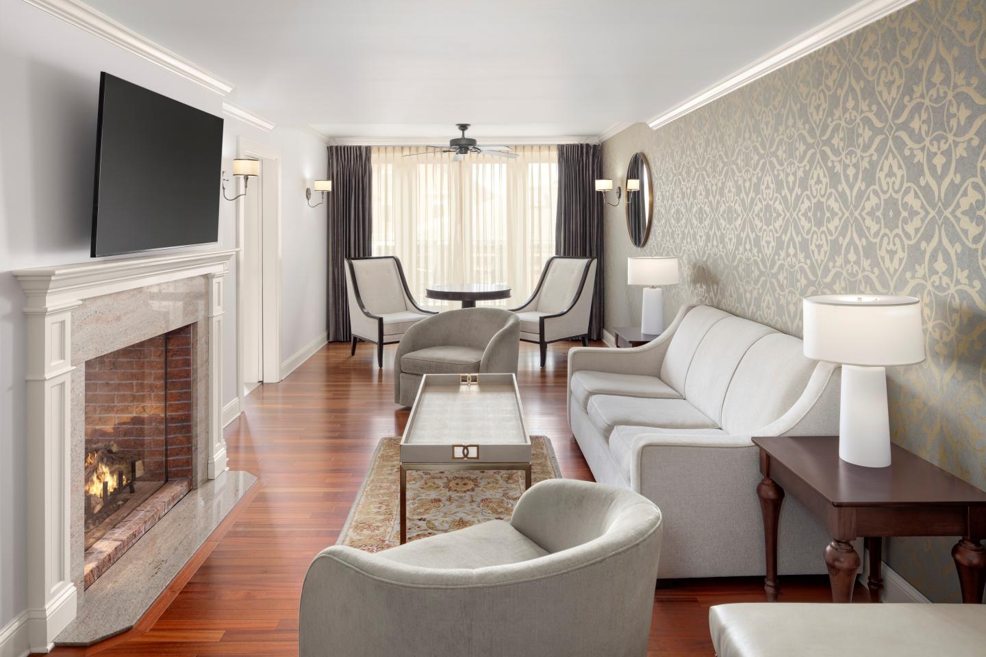 Elegant living room with modern furniture, fireplace, and large TV.