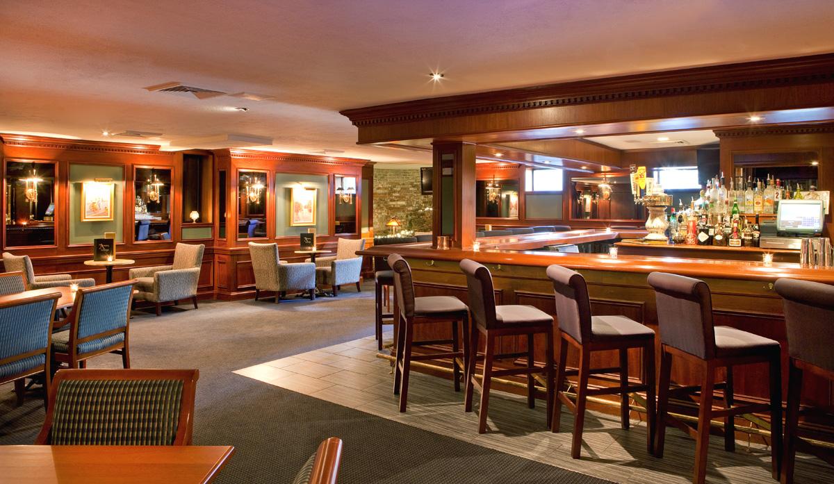 Cozy bar with warm lighting and wooden furniture.