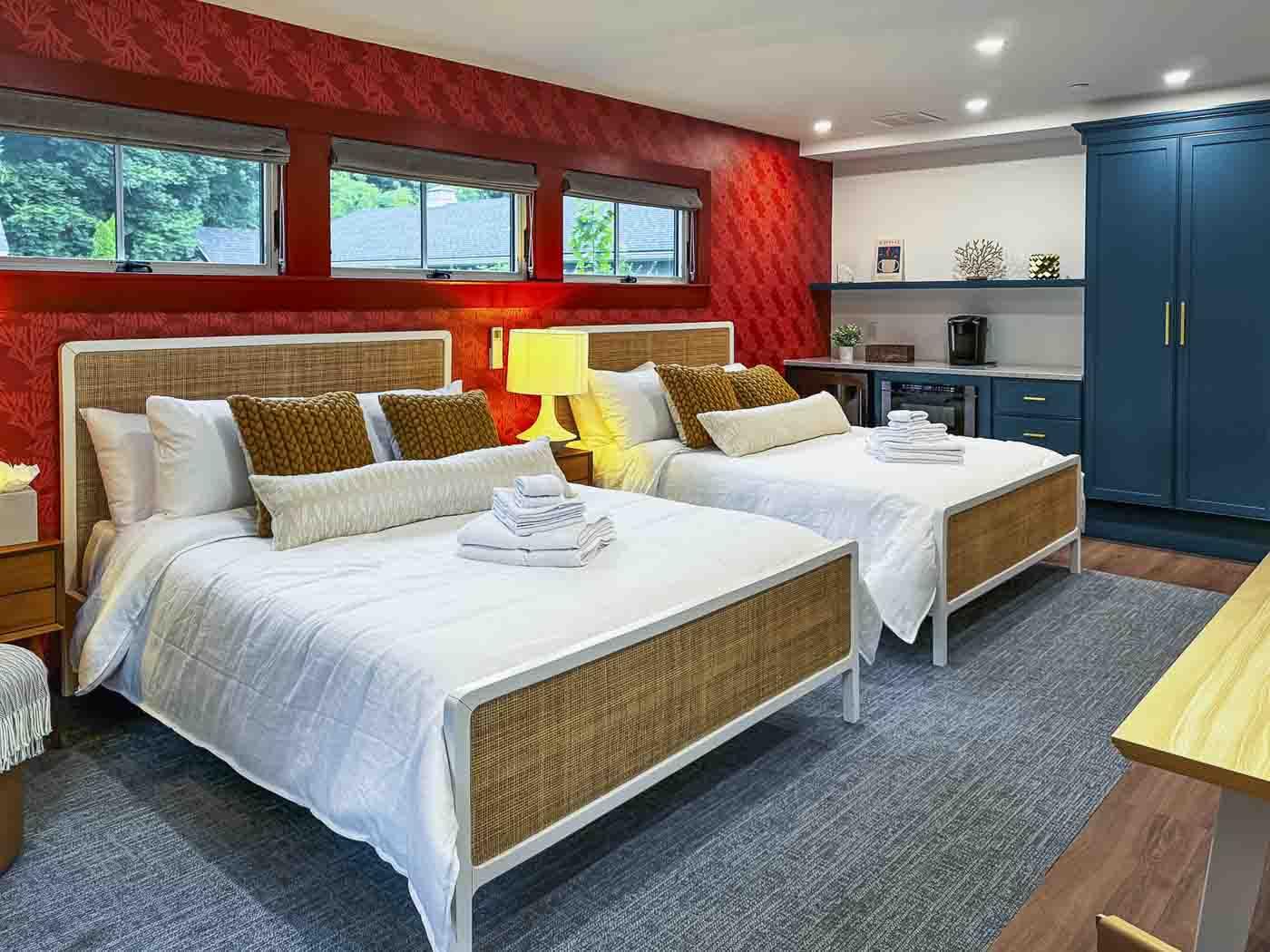 Two neatly made beds in a colorful, modern bedroom.