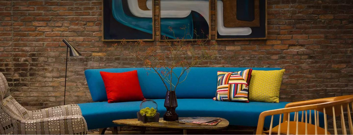 Colorful modern living room with blue sofa and vibrant cushions.