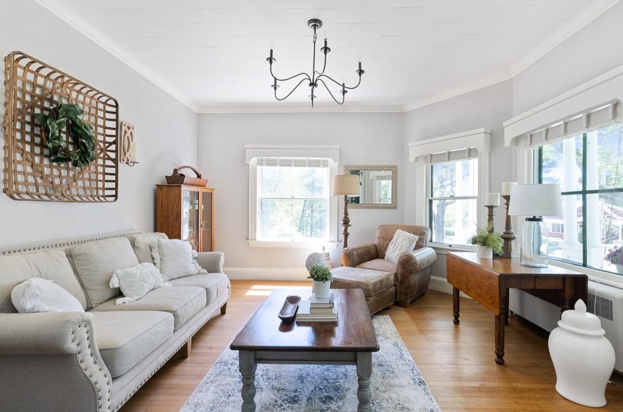 Cozy living room with beige sofa, armchair, and wooden coffee table. Bright and airy feel.