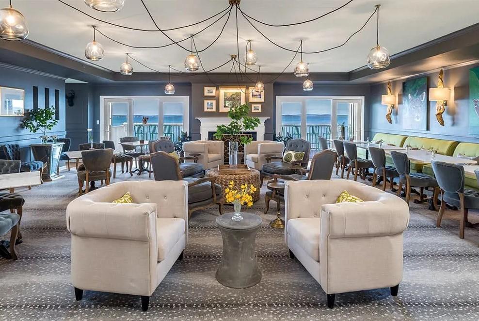 Luxurious lounge with plush seating, chandeliers, and large windows.