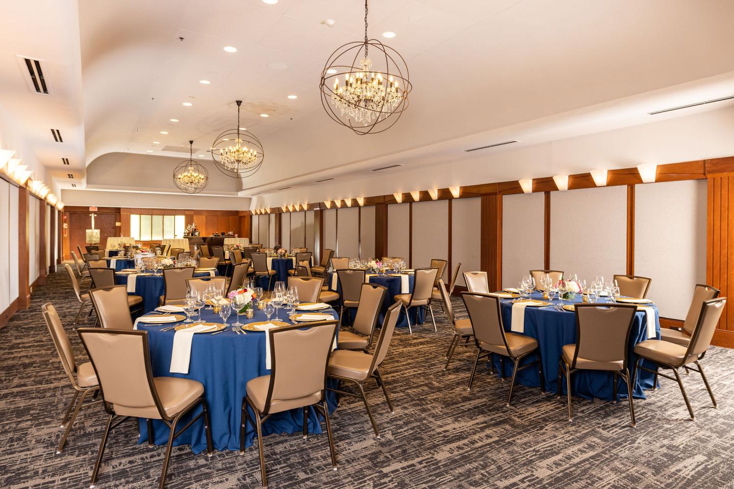 Elegant meeting room with chandelier and round tables for banquet dining