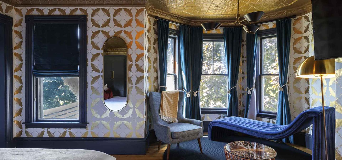 Elegant room with patterned walls, blue drapes, and modern furniture.