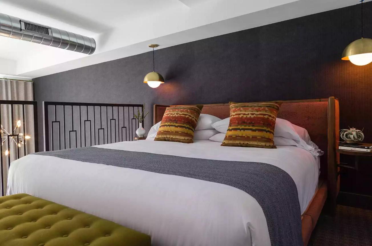 Cozy bedroom with a large bed, decorative pillows, and modern lighting.