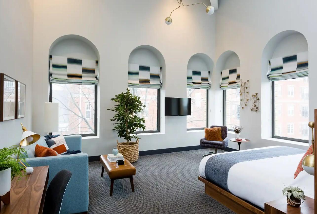 Spacious bedroom with large arched windows and modern decor.King