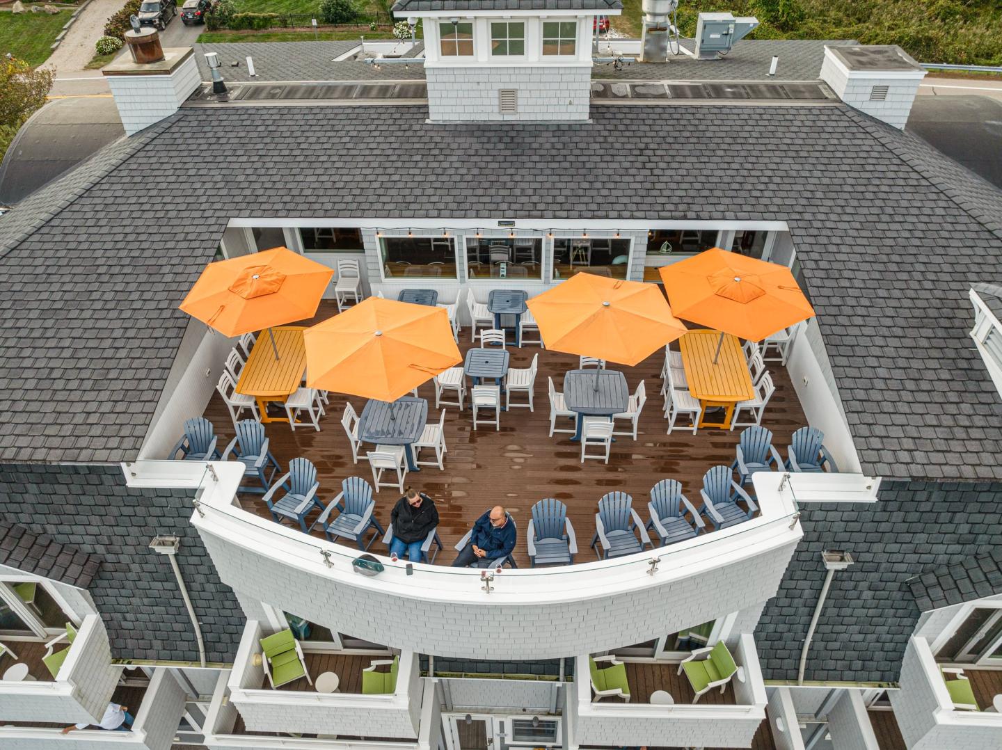 Rooftop patio with orange umbrellas and lounge chairs.