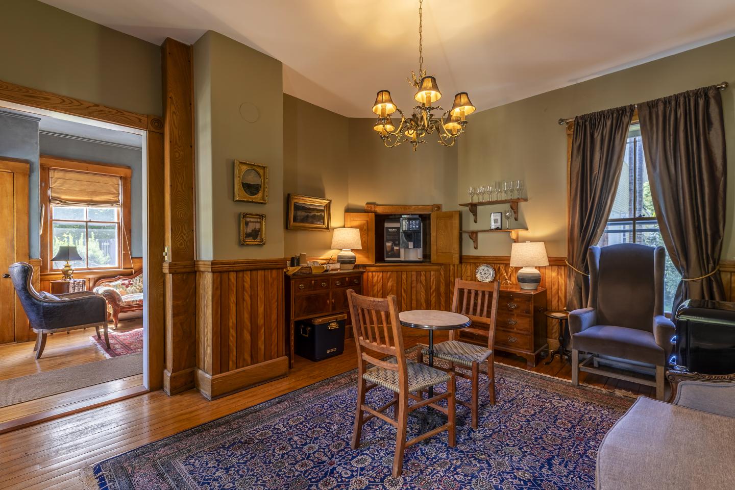 Cozy vintage coffee lounge with wooden furniture, soft lighting, and a patterned rug.