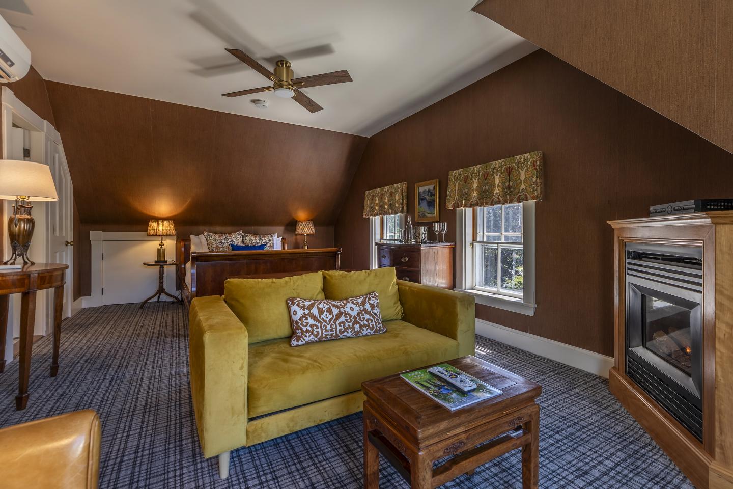 Cozy room with a yellow sofa, fireplace, and wooden furniture.