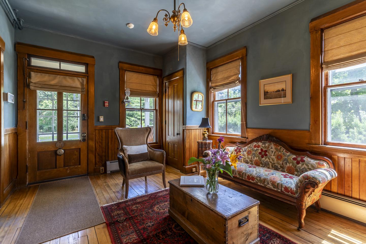 Cozy living room with vintage sofa, armchair, and wooden decor.