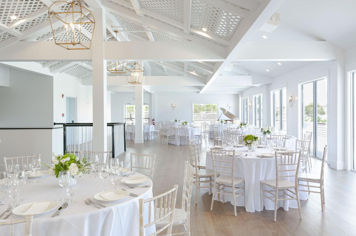 Bright banquet hall with round tables set for an event.