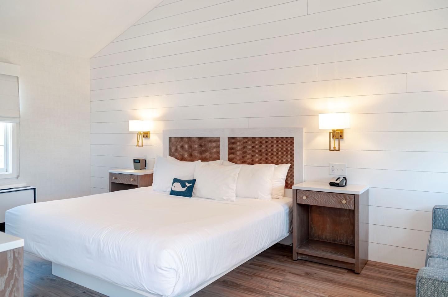 A bright bedroom with a large bed and two bedside tables.