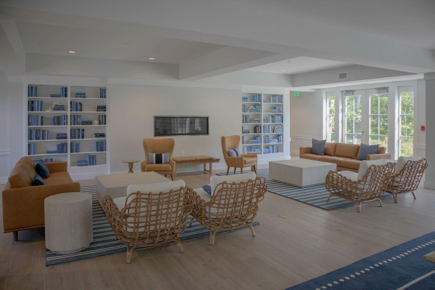 Spacious lounge with wicker chairs, sofas, and bookshelves.