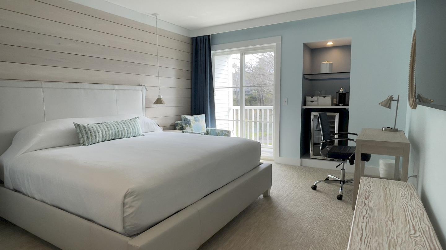 Modern bedroom with a large bed, desk, and window with curtains. Neutral tones and soft lighting.Room 2