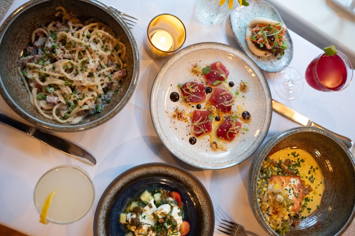 Aerial view of a table set with various gourmet dishes and two drinks.