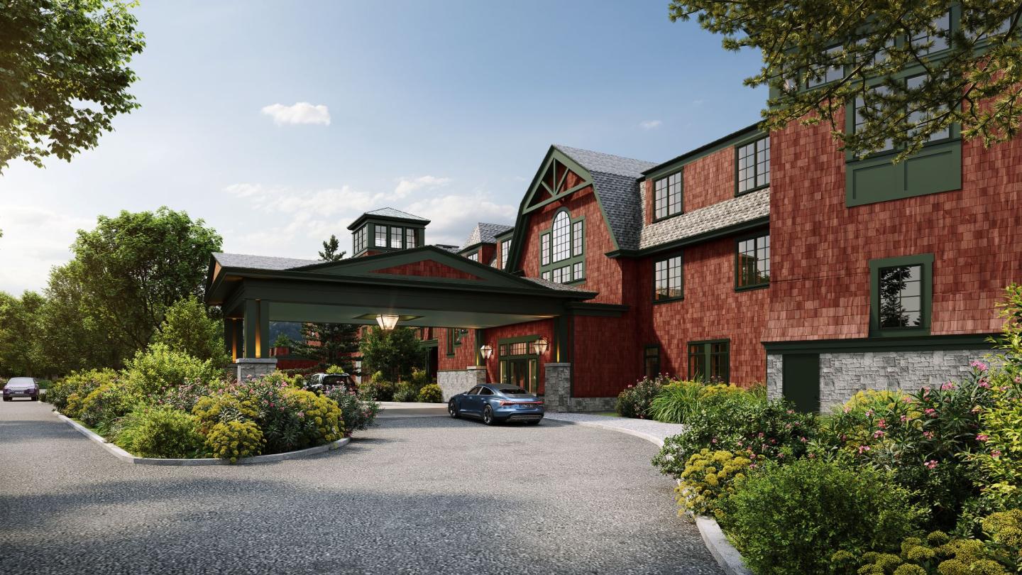 Red brick building with greenery under a clear blue sky.
